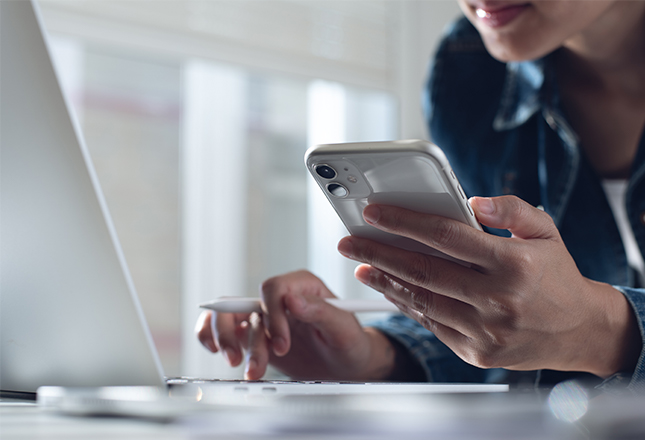 personne qui consulte ordinateur et portable